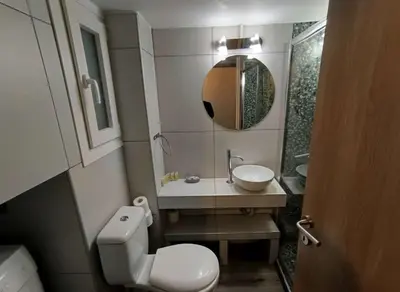 a bathroom with a toilet and a sink and a mirror at The Athenian Nest 2-Bedroom Apartment in Metaxou in Athens