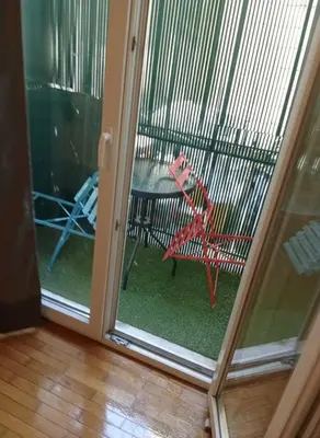 a sliding glass door with a red bird in a cage at The Athenian Nest 2-Bedroom Apartment in Metaxou in Athens