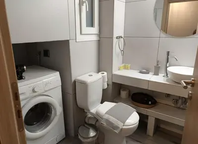 a bathroom with a washing machine and a sink at The Athenian Nest 2-Bedroom Apartment in Metaxou in Athens