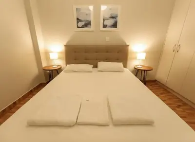 a large white bed in a room with two tables at Heritage Retreat by Acropolis & Museum in Athens