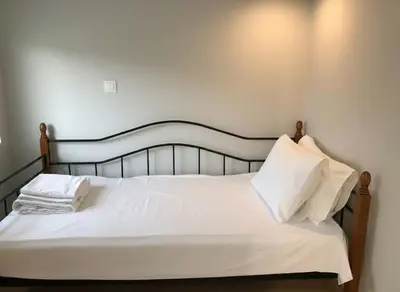 a bed with white sheets and pillows in a room at Heritage Retreat by Acropolis & Museum in Athens