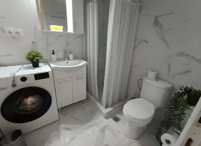 a white bathroom with a toilet and a sink at Heritage Retreat by Acropolis & Museum in Athens
