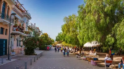a group of people walking down a street with trees at Heritage Retreat by Acropolis & Museum in Athens