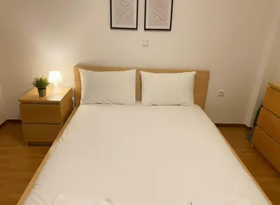 a bed with white sheets and pillows in a bedroom at Athenas Residence 3-Bedroom Apartment in Alimos in Athens