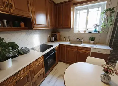 a kitchen with wooden cabinets and a sink and a table at Athenas Residence 3-Bedroom Apartment in Alimos in Athens