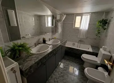 a bathroom with two sinks and a tub and a toilet at Athenas Residence 3-Bedroom Apartment in Alimos in Athens