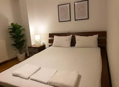 a bedroom with a large bed with white sheets and pillows at Athenas Residence 3-Bedroom Apartment in Alimos in Athens