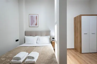 a bedroom with a bed with two towels on it at Acropolis Canvas-3BDR in Athens