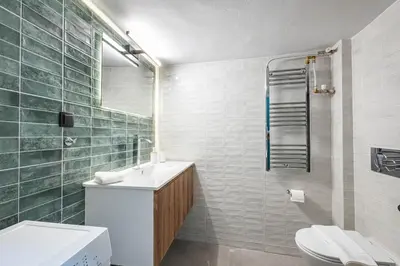 a bathroom with a sink and a toilet and a mirror at Acropolis Canvas-3BDR in Athens