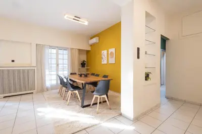 a dining room with a wooden table and chairs at Acropolis Canvas-3BDR in Athens