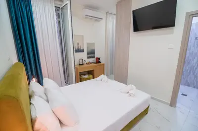 a bedroom with a white bed and a television at Monza in Athens