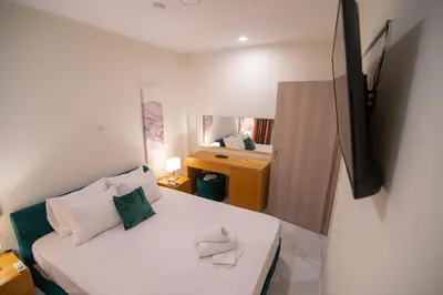 a small bedroom with a bed and a mirror at Monza in Athens