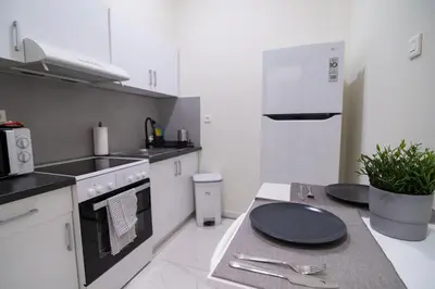 a kitchen with white cabinets and a stove top oven at Monza in Athens