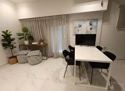 a living room with a white table and chairs at Cozy 1-Bedroom Apartment in Pagkrati Close to Metro in Athens