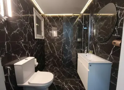 a black marble bathroom with a toilet and a sink at Cozy 1-Bedroom Apartment in Pagkrati Close to Metro in Athens