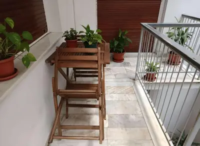 a stairway with a wooden table and potted plants at Cozy 1-Bedroom Apartment in Pagkrati Close to Metro in Athens