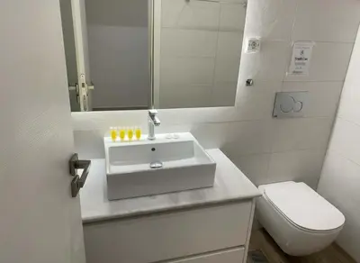 a white bathroom with a sink and a toilet at Athens at Your Doorstep Chic Syntagma Apartment in Athens