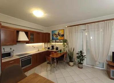 a kitchen with wooden cabinets and a table in it at Urban Comfort Stay in Peristeri in Athens