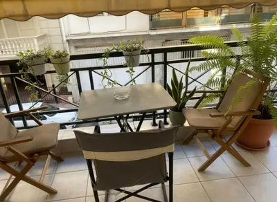 a table and chairs on a balcony with plants at Urban Comfort Stay in Peristeri in Athens