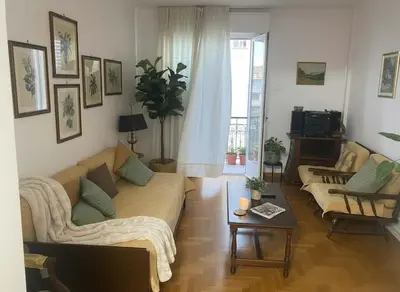 a living room with a couch and a table at Family-Friendly Comfort in the Heart of Koukaki in Athens