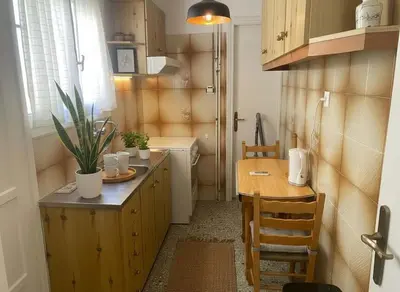 a kitchen with a counter and a table and a sink at Family-Friendly Comfort in the Heart of Koukaki in Athens