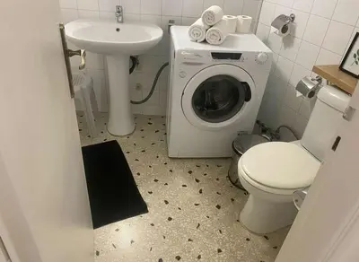 a bathroom with a washing machine and a sink at Family-Friendly Comfort in the Heart of Koukaki in Athens