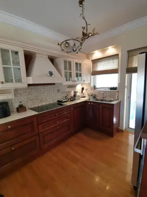 a large kitchen with wooden floors and a chandelier at Luxurious maisonette 4 metro stops to Acropolis in Athens