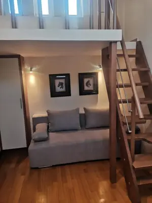 a couch in a living room with a staircase at Luxurious maisonette 4 metro stops to Acropolis in Athens