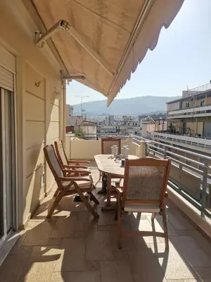 a patio with chairs and a table on a balcony at Luxurious maisonette 4 metro stops to Acropolis in Athens