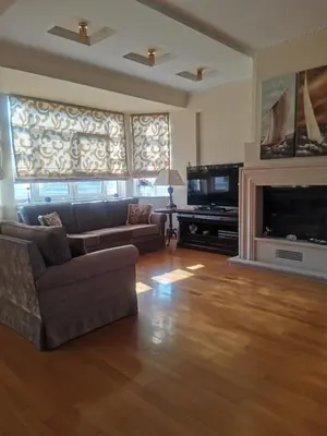 a living room with a couch and a television at Luxurious maisonette 4 metro stops to Acropolis in Athens