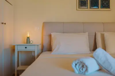 a bedroom with a bed with a candle on a table at Modern 2BR Apt Glyfada Center and Private Veranda in Athens