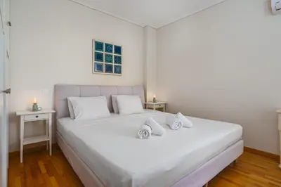 a bedroom with a white bed with two white towels on it at Modern 2BR Apt Glyfada Center and Private Veranda in Athens