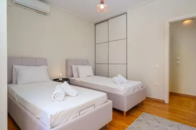 a bedroom with two beds and a couch at Modern 2BR Apt Glyfada Center and Private Veranda in Athens