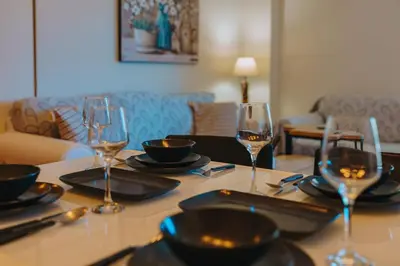 a table with wine glasses and plates on it at Modern 2BR Apt Glyfada Center and Private Veranda in Athens