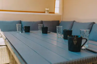 a blue table with cups and glasses on it at Modern 2BR Apt Glyfada Center and Private Veranda in Athens