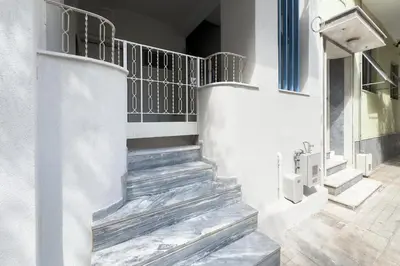 a staircase in a white building with a stair railing at Stylish Home in Petralona in Athens