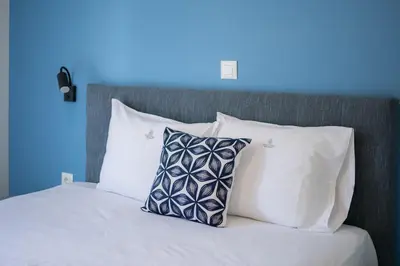 a bed with white pillows and a blue wall at Stylish Home in Petralona in Athens