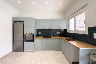 a kitchen with white cabinets and a stainless steel refrigerator at Stylish Home in Petralona in Athens