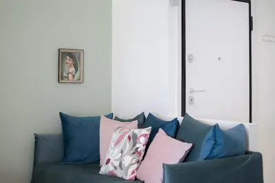 a blue couch with many pillows on it at Stylish Home in Petralona in Athens