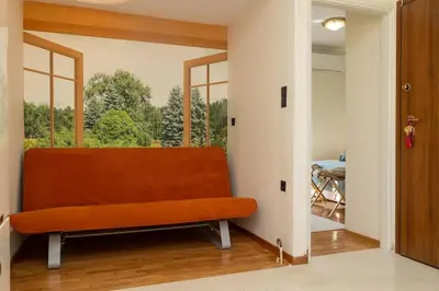 an orange couch in a room with a window at Krisila Boutique Stay in Athens