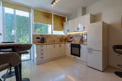 a kitchen with white appliances and a table and chairs at Krisila Boutique Stay in Athens