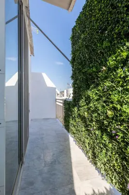 a hallway with a green hedge next to a building at Krisila Boutique Stay in Athens