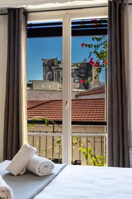 a bed with a view of a city from a window at Athens Nala in Athens