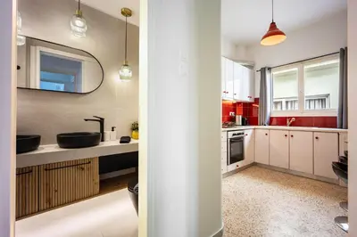 a kitchen with white cabinets and a sink and a mirror at Athens Nala in Athens