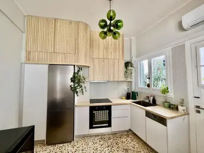 a kitchen with white cabinets and a stainless steel refrigerator at Athens Classic 2- Bedroom Apartment in Athens