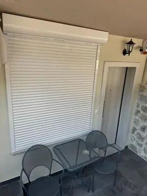 a glass table and chairs in a room with a window at Cozy, Quiet & Modern Apartment in Athens