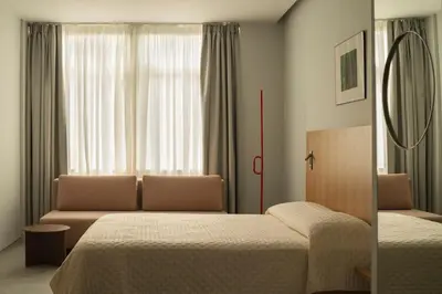 a bedroom with two beds and a couch and a window at P28 Suite 104 in Athens