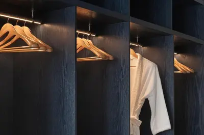 a black closet with hangers and white shirts at P28 Suite 109 in Athens