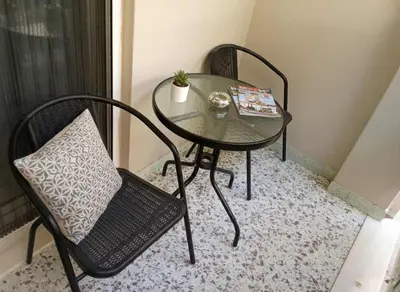 a glass table and chair with a book on it at Modern 1BD Kallithea Home with Patio in Athens