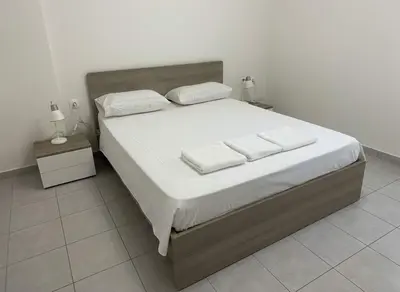 a bedroom with a large bed with white sheets and pillows at Modern 1BD Kallithea Home with Patio in Athens